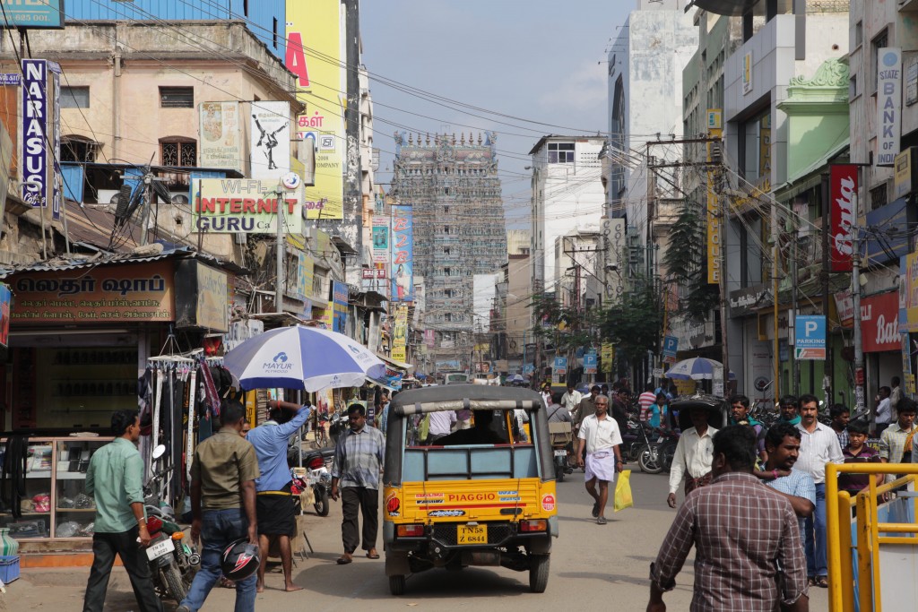 A busy street in Madurai, one of the Meenakshi temple's four towers in the distance