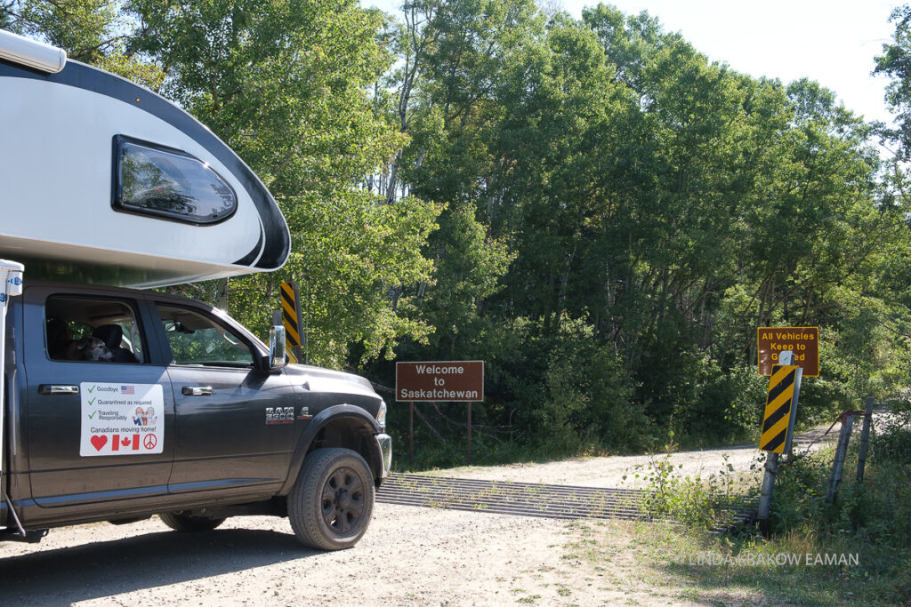 Our camper sits in front of a sign that says "welcome to saskatchewan"